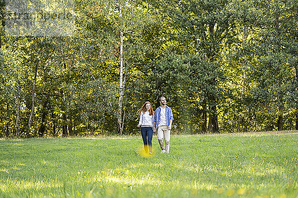 Lächelndes junges Paar bei einem Spaziergang in einem Park
