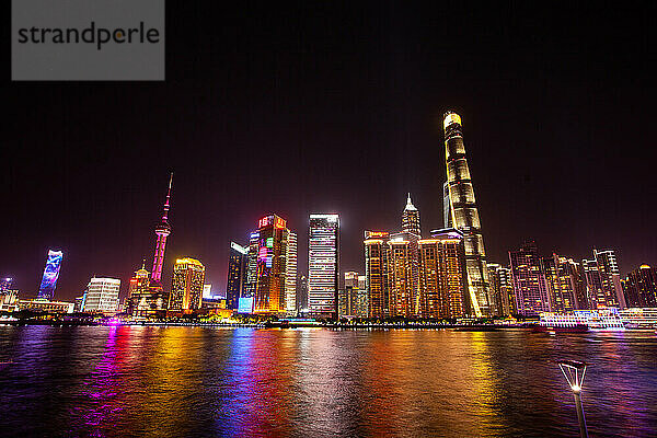 Skyline von Shanghai  die sich nachts im Huangpu-Fluss spiegelt