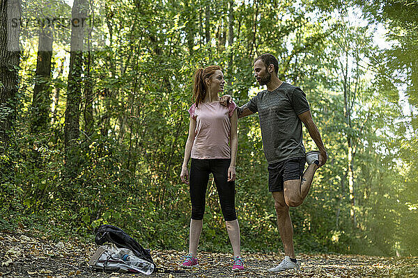 Junges Paar trainiert auf einem Weg im Wald