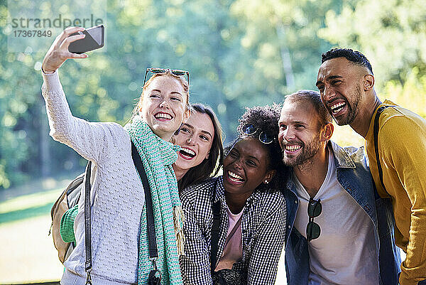 Glückliche Freunde machen ein Selfie mit ihrem Smartphone in einem öffentlichen Park