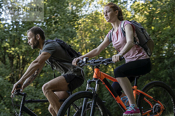 Junges Paar fährt Fahrrad im Wald