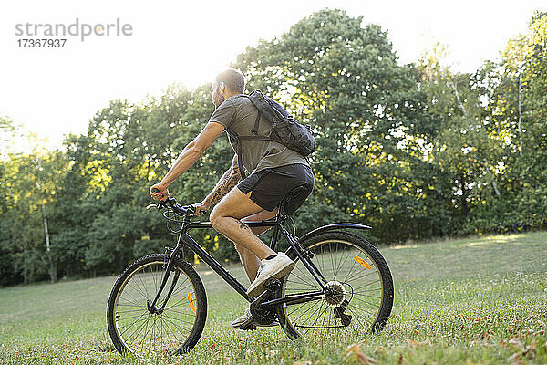 Junger Mann fährt mit dem Fahrrad im Wald
