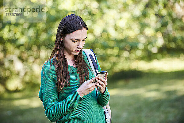 Junge Frau schreibt eine SMS auf einem Smartphone