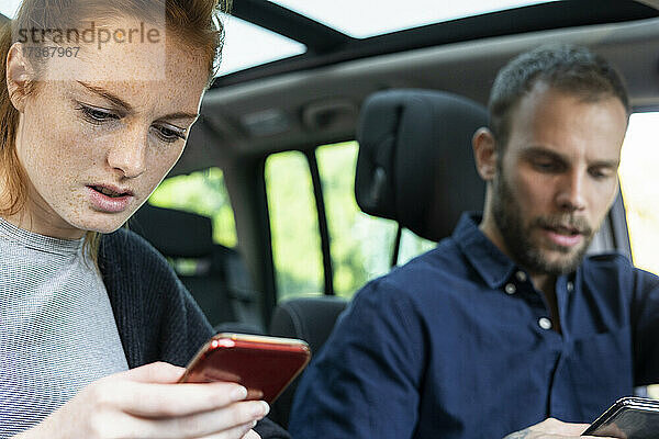 Ängstliches junges Paar benutzt Smartphones