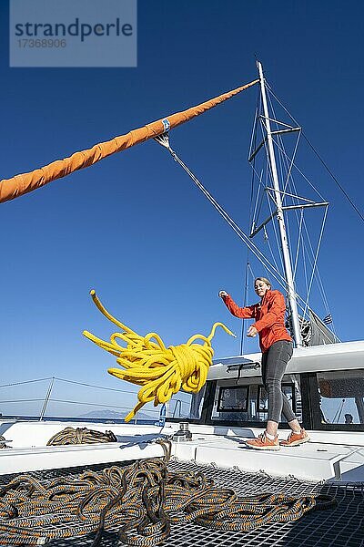 Junge Frau schmeißt ein Tau auf Deck  Segel-Katamaran  Segeltörn  Dodekanes  Griechenland  Europa