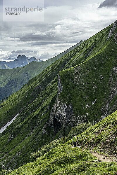 Wanderin auf einem Wanderweg  Abstieg von der Rappenseehütte  hinten felsige Berggipfel  Allgäuer Alpen  Allgäu  Bayern  Deutschland  Europa