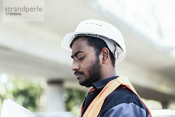 Junger Techniker mit Bart außen mit Helm arbeitenda an einer Brücke  Baden-Württemberg  Deutschland  Europa