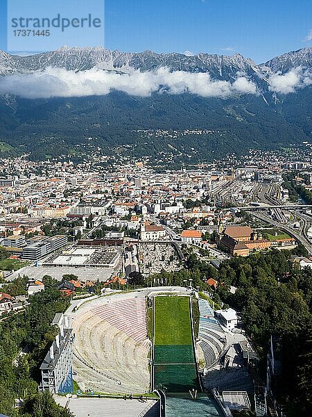 Blick von der Bergisel Schanze hinab zum Stadion  Skispringer  dahinter die Stadt Insbruck  am Horizont die Nordkette  Innsbruck  Tirol  Österreich  Europa