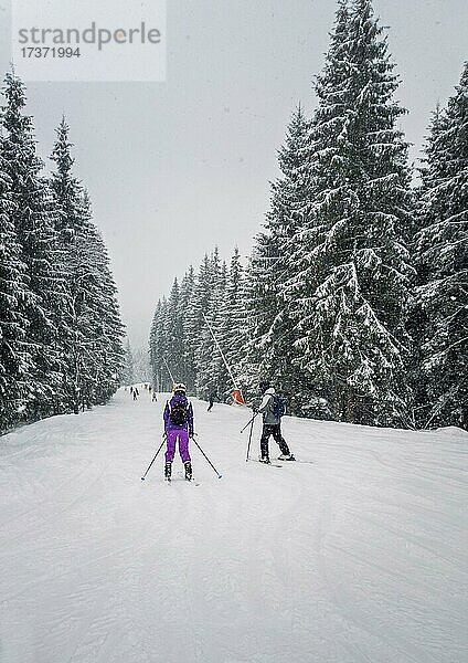 Menschen Skifahren auf der verschneiten Piste von Bukovel Skigebiet in den ukrainischen Karpaten. Schnee fallen Szene  Schneesturm frostigen Wetter in der Ukraine