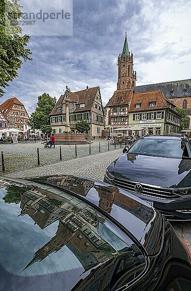 Der Marktplatz mit Mariensäule am Brunnen und der Turm der katholischen Kirche St. (Gallus) spiegeln sich auf der Kühlerhaube eines Autos  Ladenburg  Baden-Württemberg  Deutschland  Europa