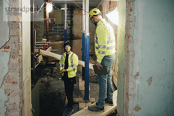 Männliche Ingenieure besprechen sich auf der Baustelle