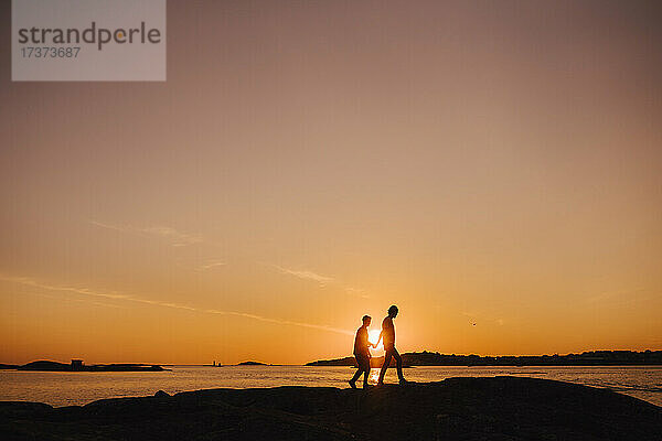 Homosexuelles Paar verbringt seine Freizeit bei einem Spaziergang während des Sonnenuntergangs