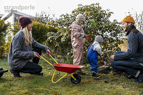 Glückliche Familie bei der gemeinsamen Gartenarbeit im Hinterhof