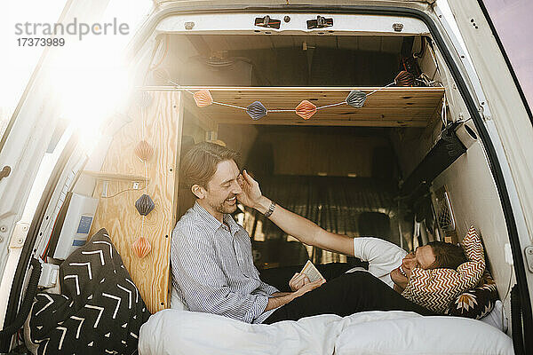 Glückliches schwules Paar verbringt seine Freizeit im Campingbus während des Urlaubs