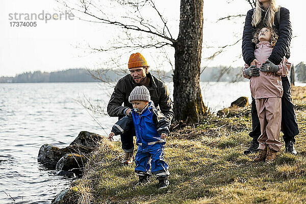 Mann und Frau mit Sohn und Tochter am See im Park