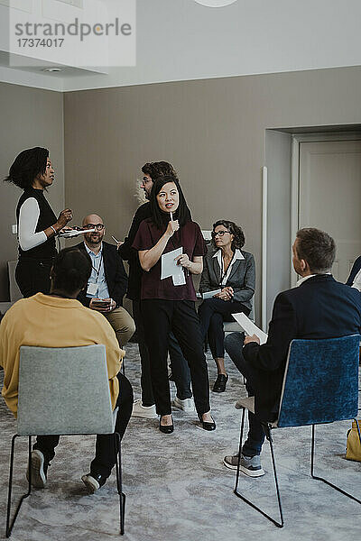 Männliche und weibliche Angestellte diskutieren bei einem Treffen in einer Bildungseinrichtung