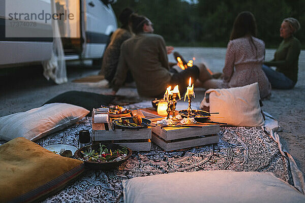 Weibliche und männliche Freunde unterhalten sich im Urlaub im Campingbus