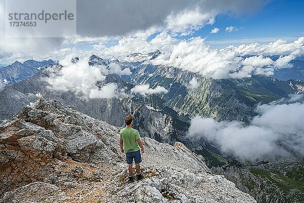 Wanderer am Gipfel der Partenkirchner Dreitorspitze  Blick ins Reintal auf wolkenverhangene Gipfel  hinten Zugspitzplatt und Zugspitze  Wettersteingebirge  Garmisch Partenkirchen  Bayern  Deutschland  Europa