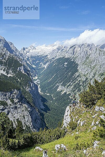 Wanderer blickt in die Kamera  Ausblick ins Reintal  hinten Gipfel der Zugspitze und Alpspitze mit Zugspitzplatt  Wanderweg zur Meilerhütte  Wettersteingebirge  Garmisch Partenkirchen  Bayern  Deutschland  Europa