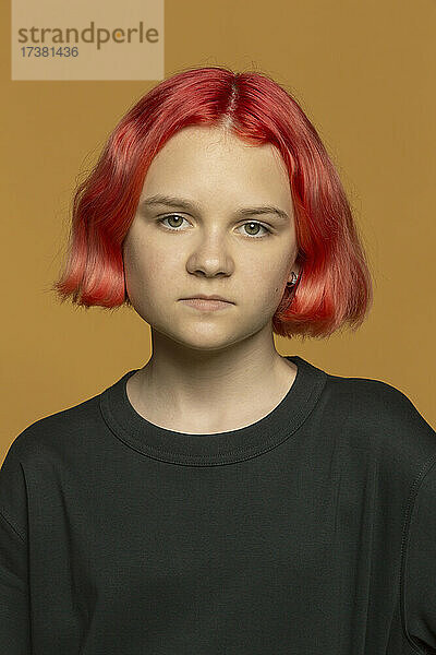 Porträt ernsthaftes jugendliches Mädchen mit gefärbten roten Haaren