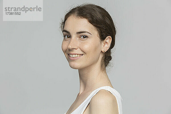 Porträt lächelnde junge Frau vor weißem Hintergrund