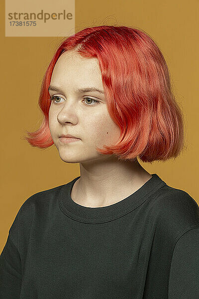 Porträt nachdenkliches jugendliches Mädchen mit gefärbten roten Haaren