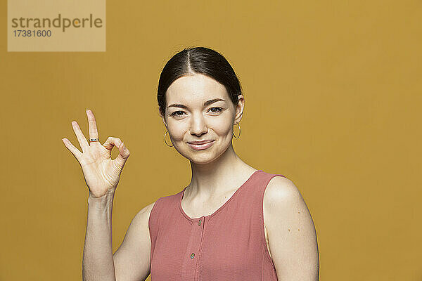 Porträt glückliche junge Frau mit Geste OK