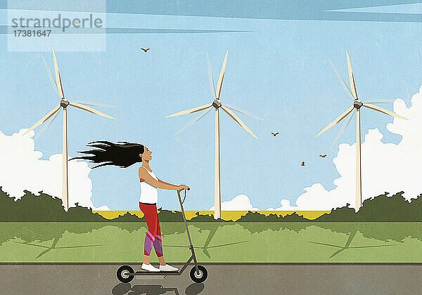 Unbekümmerte Frau fährt mit einem Elektroroller an Windrädern entlang