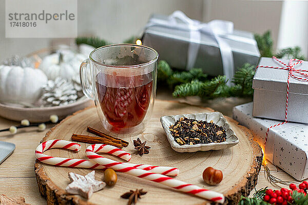 Weihnachten  ein Glas Glühwein oder Wein auf einem Tisch mit Gewürzen  Zuckerstangen