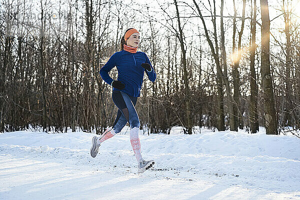 Junge Frau joggt im Schnee