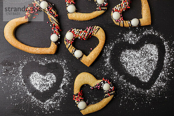 Studio shot of heart shaped cookies flat laid against black background
