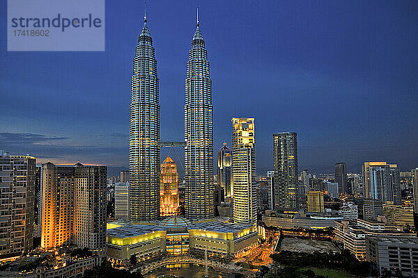 Malaysia  Kuala Lumpur  Petronas Towers und die umliegenden Wolkenkratzer in der Innenstadt in der Abenddämmerung