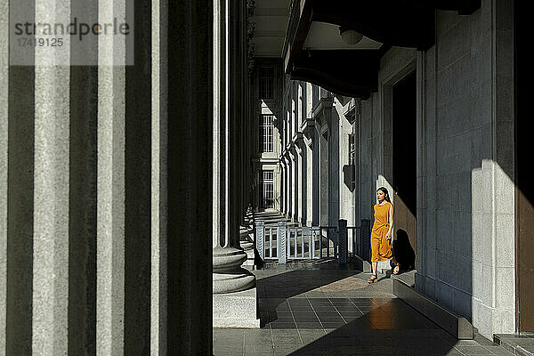 Junge Frau geht vor der National Gallery in Singapur spazieren