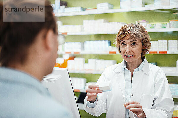 Apothekerin erklärt Kunden Medikamente in der Apotheke