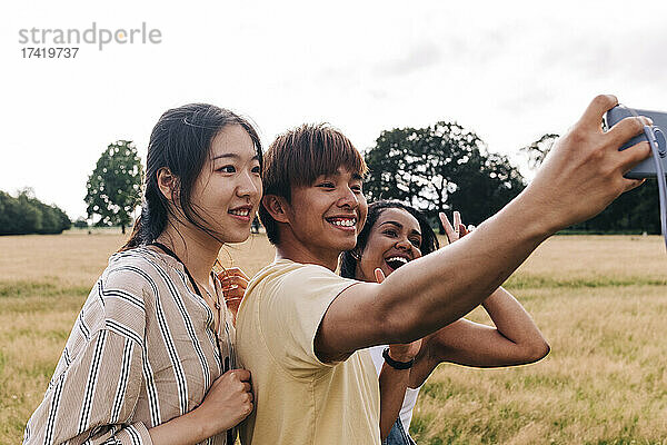 Glückliche Freunde  die im Park ein Selfie mit dem Smartphone machen