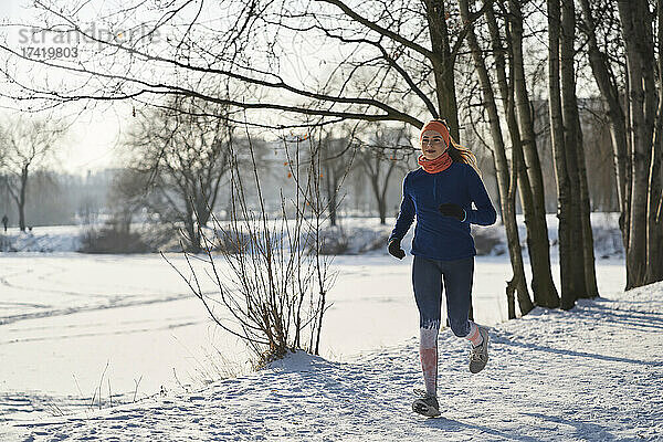 Junge Frau joggt im Schnee