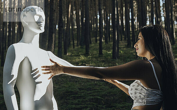 Junge Frau blickt an einem sonnigen Tag auf den Roboter