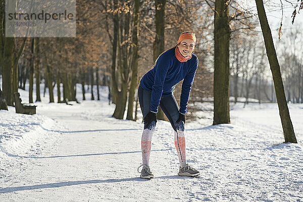Lächelnde Frau macht beim Training im Winter eine Pause