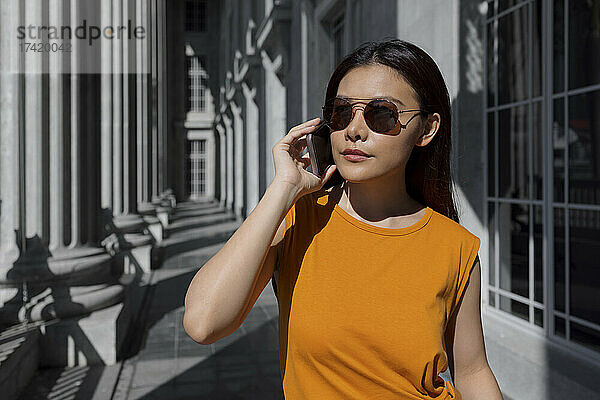 Frau mit Sonnenbrille beim Telefonieren in der National Gallery Singapore  Singapur