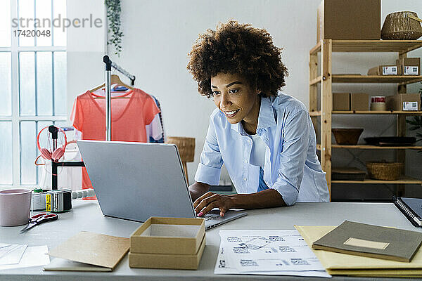 Modedesignerin benutzt Laptop während der Arbeit im Studio