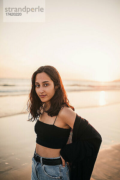 Junge Frau am Strand bei Sonnenuntergang