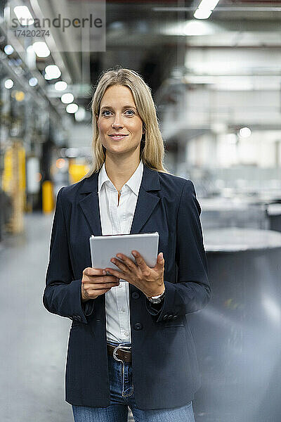 Berufstätige Frau mit digitalem Tablet in der Industrie