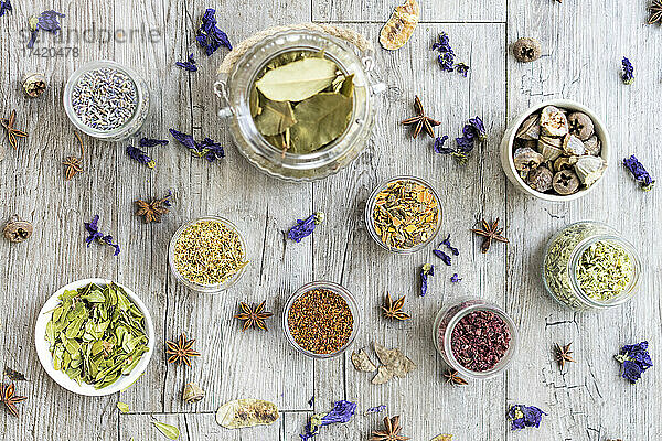 Gewürze mit Kräutern und Blumen auf dem Tisch angeordnet