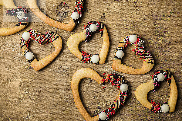 Studio shot of heart shaped cookies flat laid against brown background