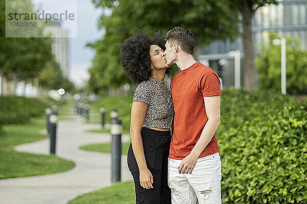 Multiethnisches Paar küsst sich im Park