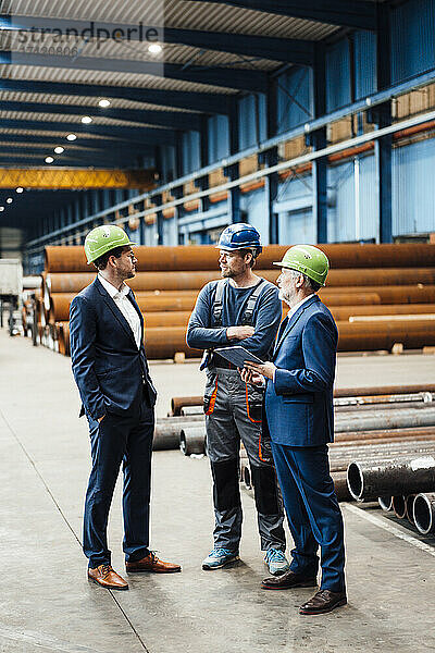Männliche Geschäftsleute diskutieren in der Metallindustrie