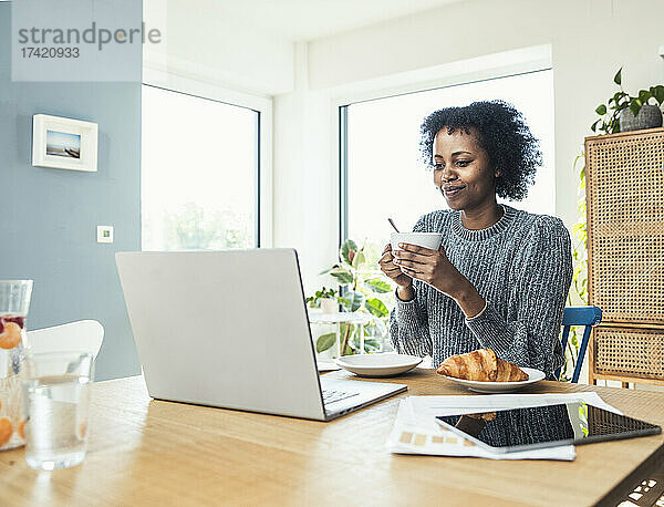 Berufstätige Frau trinkt Kaffee im Heimbüro
