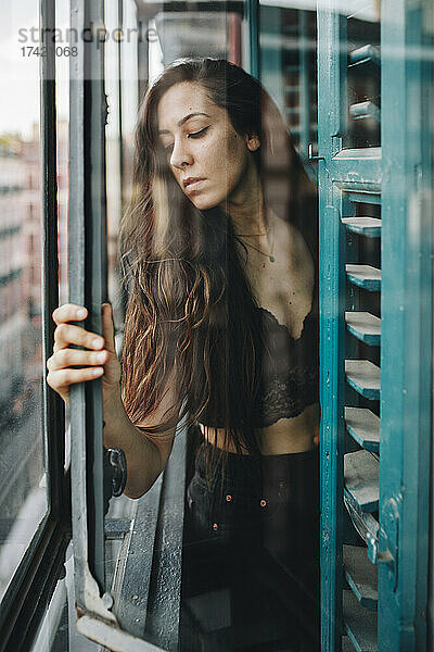 Einsame Frau hält Glasfenster