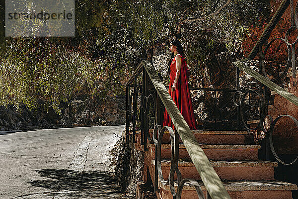 Frau im Rotkäppchenkostüm steht am Geländer