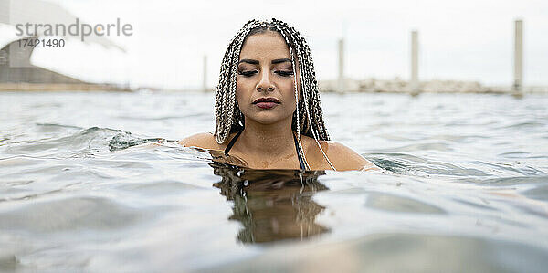 Frau mit geflochtenen Haaren im Wasser am Wochenende